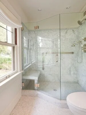 Remodeled bathroom with granite vanity and tile backsplash